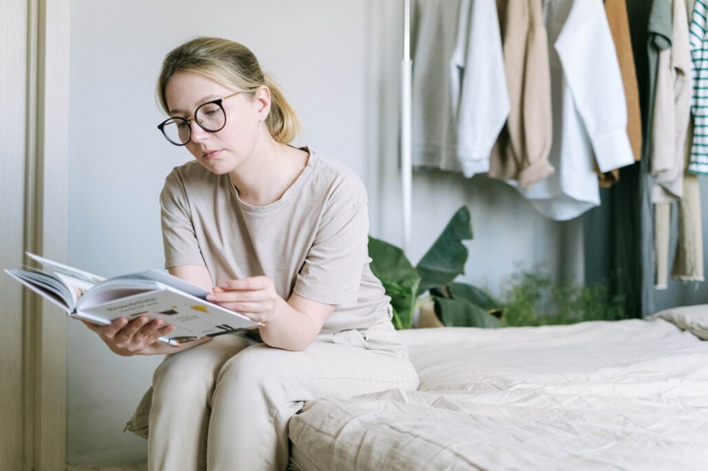 woman looking through photobook sitting on a bed