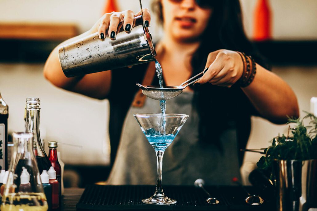 photo of woman pouring liquid from drink mixer